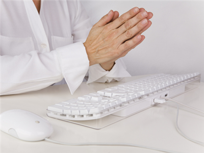 Hands in prayer over keyboard
