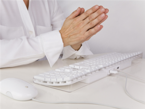 Hands in prayer over keyboard